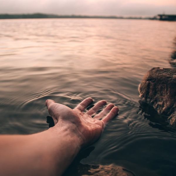 Person stretching gently outdoors during sunrise, feeling refreshed and calm.