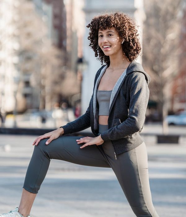 Smiling woman in sportswear feeling energetic and positive in a bright room.
